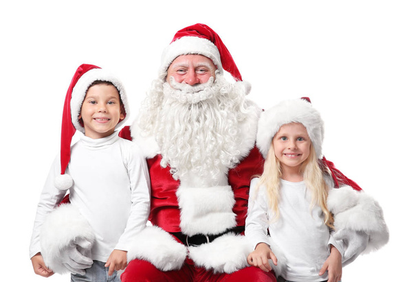 Cute kids in Christmas hats and authentic Santa Claus on white background - Foto, Imagem