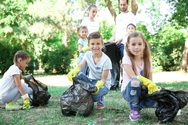 Young volunteers and children collecting garbage in park - Fotoğraf, Görsel