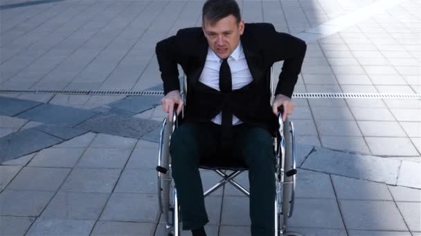 Capable handicapped businessman trying to get up from the wheelchair - Footage, Video