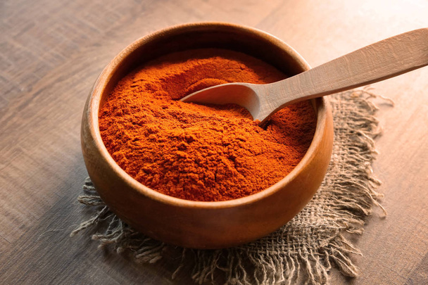 Chili powder with spoon in wooden bowl  - Photo, image
