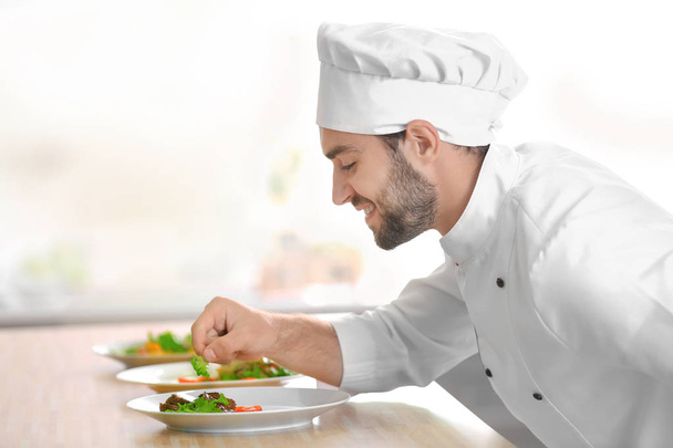 Koch hält gekochtes Gericht in Händen - Foto, Bild