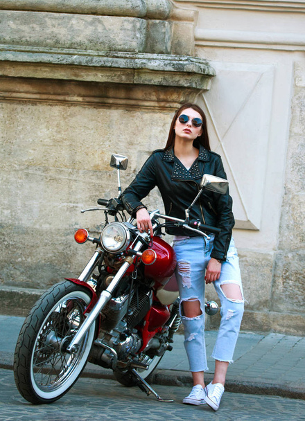 Stylish woman in leather jacket on classic motorcycle in town - Fotoğraf, Görsel