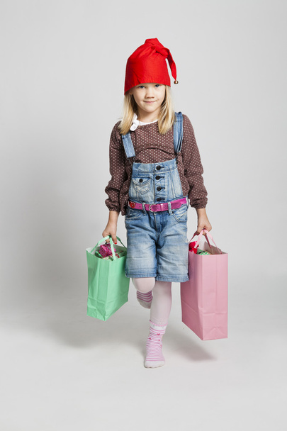 Happy young girl carrying Christmas shopping bags - Photo, image