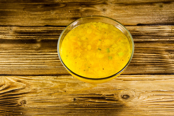 Fresh soup in glass bowl on wooden table - Zdjęcie, obraz