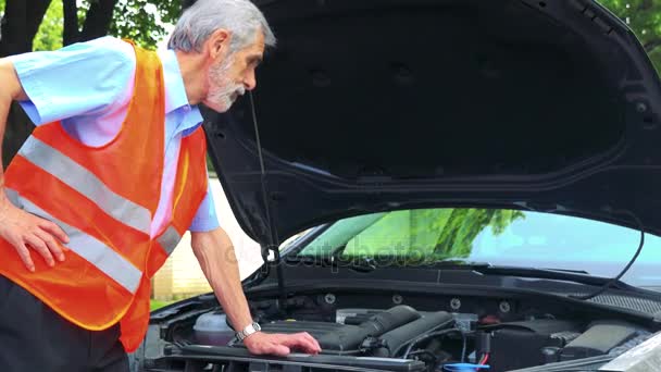 年配の男性が車のコントロール エンジン警告ベストを着ているし、彼は何をするかを知っていません。 - 映像、動画