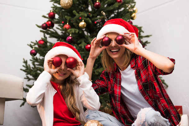 mother and daughter in santa hats  - Photo, image