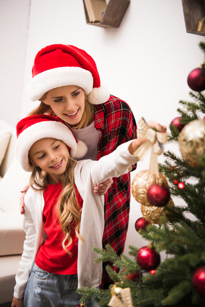 mother and daughter decorating christmas tree - Фото, изображение