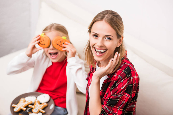 mother and daughter with halloween cookies - 写真・画像