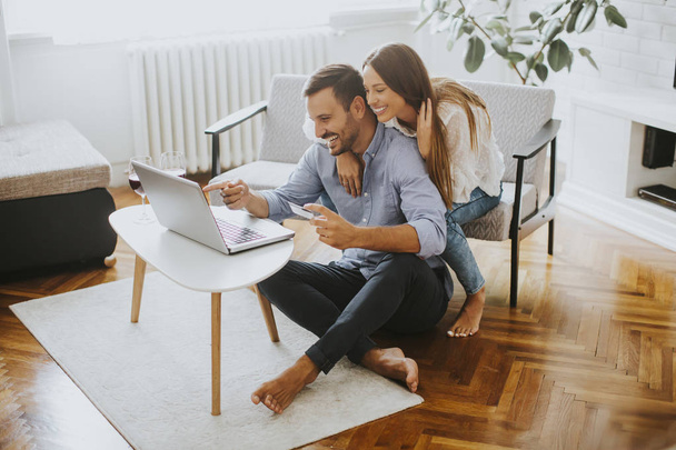 Fröhliches Paar sucht Internet auf Laptop zu Hause - Foto, Bild