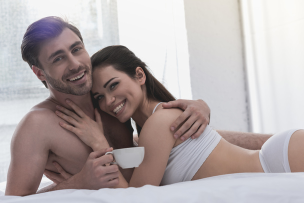 echtpaar in bed met koffie - Foto, afbeelding