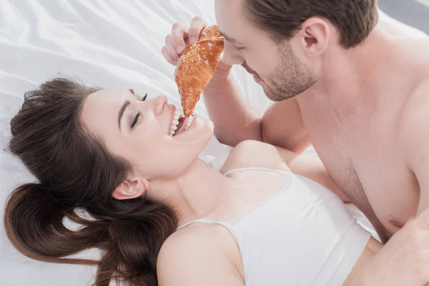 man feeding his girlfriend in bed - Zdjęcie, obraz