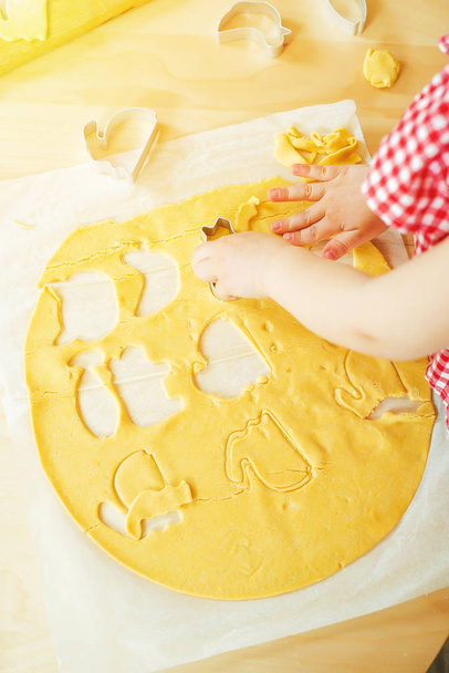 Kinderhände schneiden Kekse aus rohem Teig, Ansicht von oben. - Foto, Bild