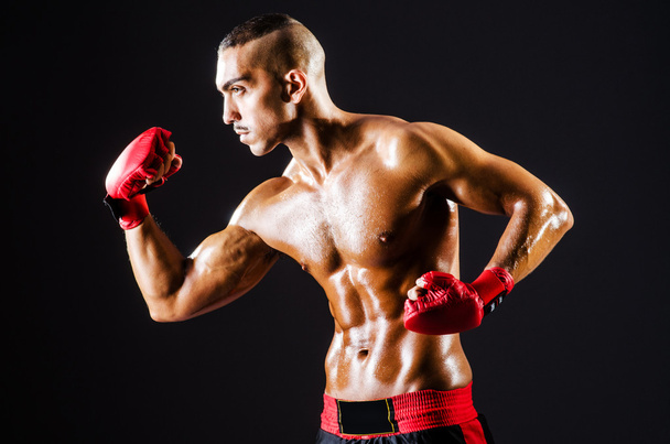 Boxeador con guantes rojos en habitación oscura
 - Foto, imagen