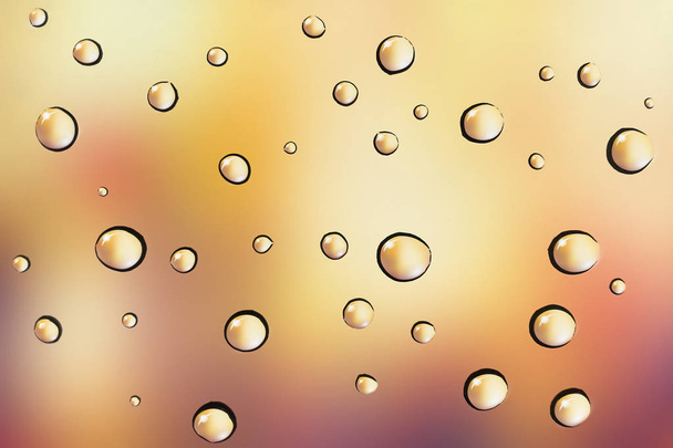 Water drops on glass background over colored bokeh - Foto, afbeelding