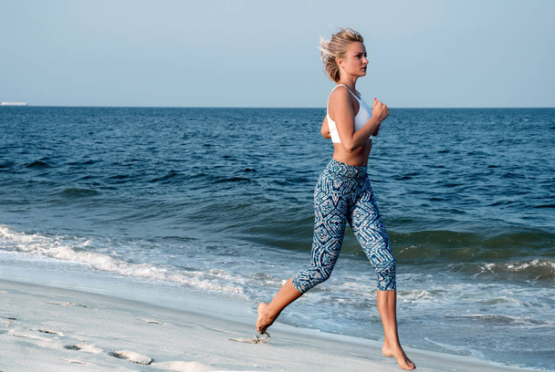  Kobiety fitness lekkoatletycznego uruchomiona na plaży. Trening na świeżym powietrzu. - Zdjęcie, obraz