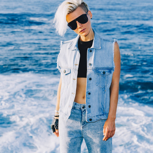 Stylish blonde outdoors in a denim look and trendy sunglasses. O - Foto, Imagem