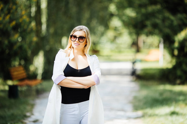 portrait of a young woman, blonde, glasses, outdoors in the park - 写真・画像