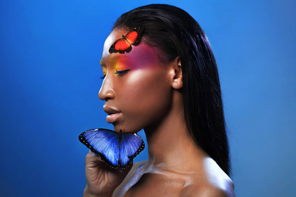 Όμορφη Αφρο κοπέλα, με δύο πεταλούδες, ομορφιά πορτραίτο σε μπλε φόντο - Φωτογραφία, εικόνα