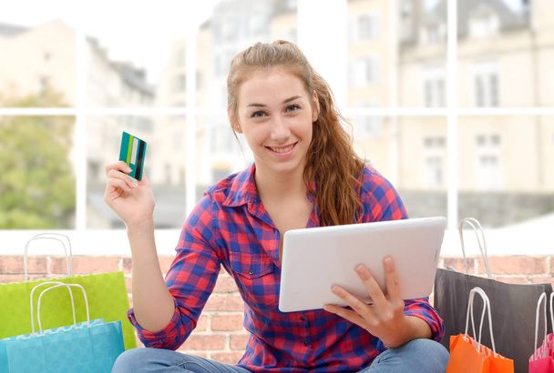 Mujer alegre sosteniendo tarjetas de crédito después de comprar
 - Foto, Imagen