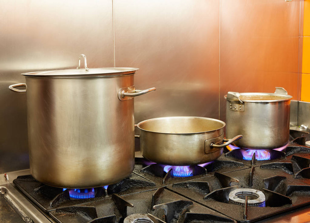 Restaurant pro kitchen with steel pans in fire - Foto, imagen