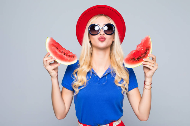 Φέτα Θεώ το καλοκαίρι. Όμορφη νεαρή γυναίκα κρατώντας φέτα καρπούζι και χαμογελώντας ενώ στέκεται απομονωθεί σε γκρι - Φωτογραφία, εικόνα
