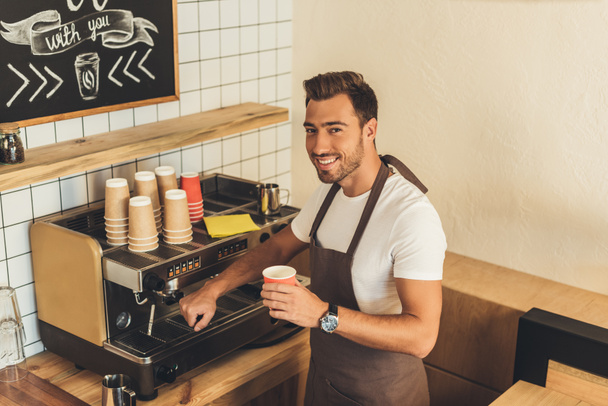 Barista souriant avec café à emporter
 - Photo, image