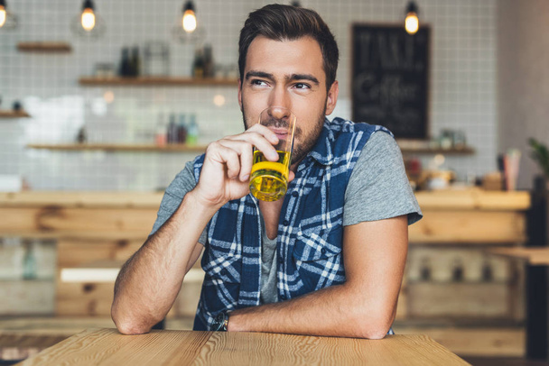 чоловік п'є сік в кафе
 - Фото, зображення