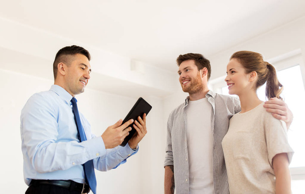 couple and realtor with tablet pc at new home - Foto, Imagem