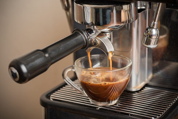 Fresh coffee flowing in a cup from espresso machine - Foto, Imagem
