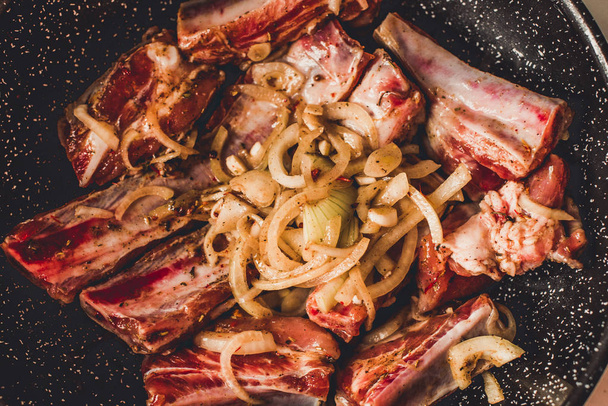 Geroosterde varkensvlees ribben met ui in koekenpan, bovenaanzicht - Foto, afbeelding