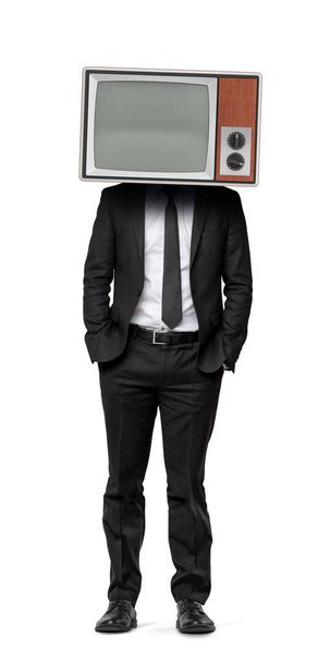 A businessman on an isolated background with hands in his pockets and an old TV instead of his head. - Φωτογραφία, εικόνα