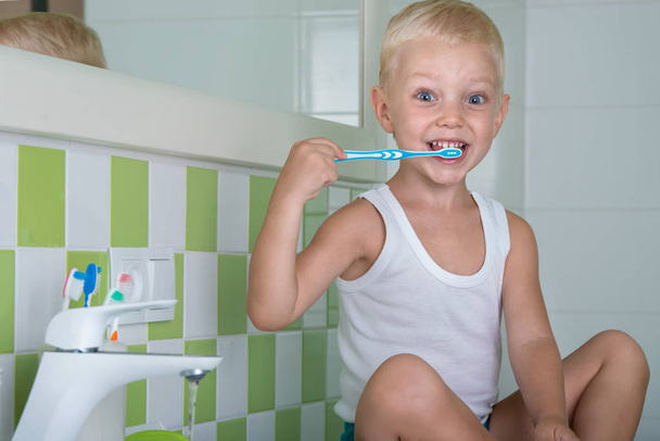 Niño pequeño cepillándose los dientes en el baño.El comienzo de un nuevo día
 - Foto, imagen