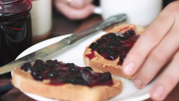 Woman eating sandwich with peanut butter and jam. - Footage, Video