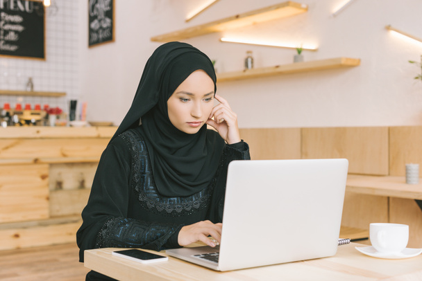 muslim woman using laptop in cafe - Foto, Imagen