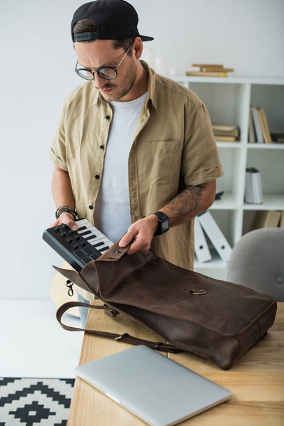 musicista mettendo pad MPC in borsa
 - Foto, immagini
