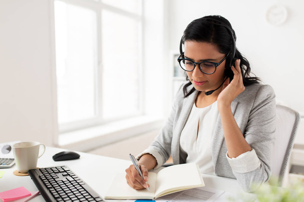 businesswoman with headset talking at office - Photo, image