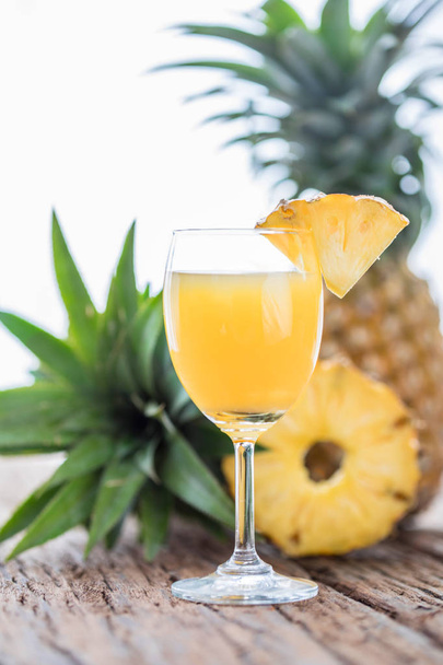 Glass of pineapple juice onwood table - Fotoğraf, Görsel