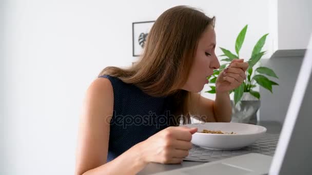 Attractive woman using her laptop while having a breakfast - Footage, Video