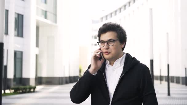 Young businessman on a phone in a city - Materiał filmowy, wideo