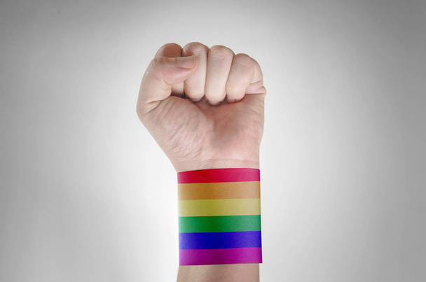 Hand mit Papierband als Regenbogenfahne gemustert - Foto, Bild