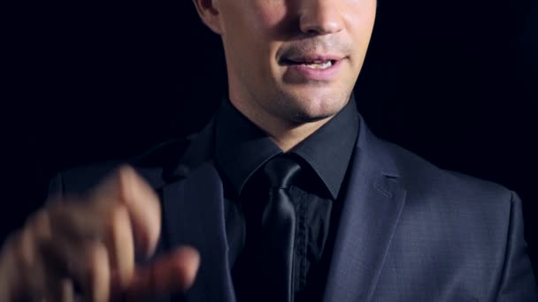 super close-up of a man in black clothes on a black background. 4k. Slow motion. man shows his hands the size of something - Footage, Video