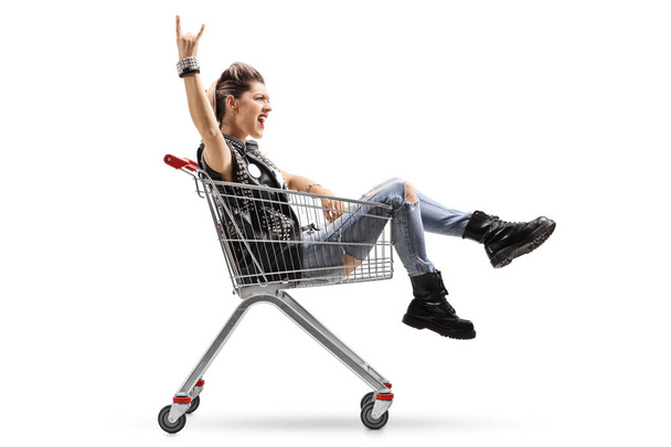 girl riding in shopping cart and making rock gesture - Fotoğraf, Görsel