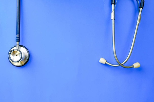 医療やヘルスケアの概念に理想的な青の背景にぶら下がっている使用される聴診器 - 写真・画像