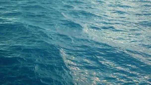 Fly over blue ocean surface in slow motion, loopable - Materiał filmowy, wideo