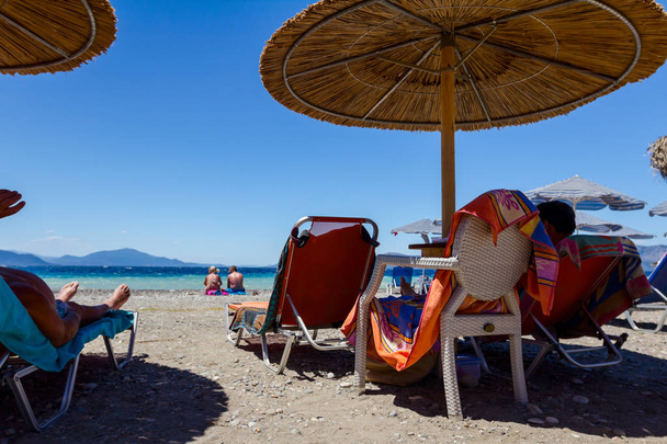 Ludzi na plaży pod parasole wykonane ze słomy i leżaki - Zdjęcie, obraz