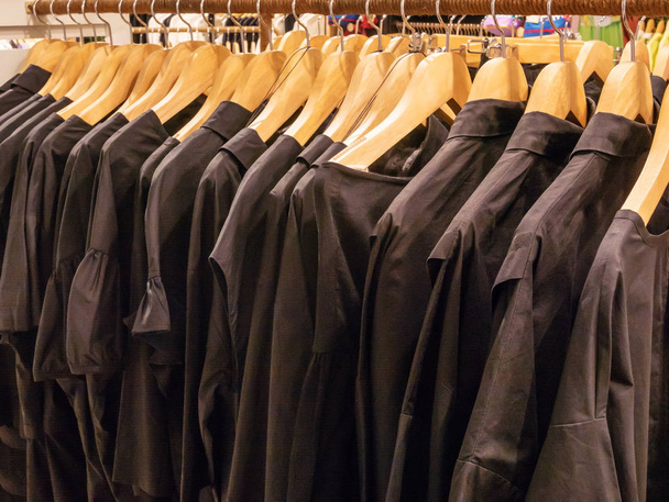 Одежда на вешалке в современном магазине
 - Фото, изображение