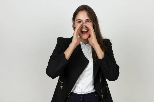Portrait of a pretty young businesswoman screaming put two hands to her face - Photo, Image