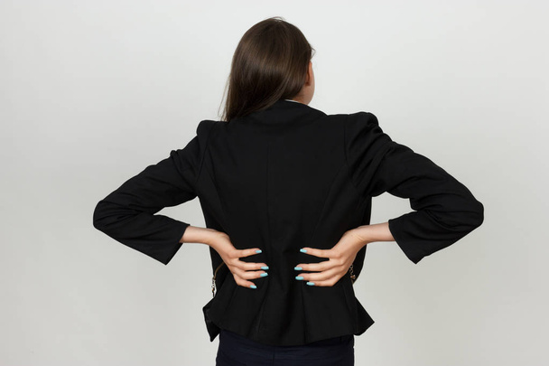  Mujer de negocios bastante joven sufre de dolor de espalda
  - Foto, Imagen