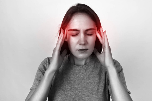Portret dziewczyny stresu i konieczności ból migrenowy ból głowy. Czarno-białe z czerwonym akcentem - Zdjęcie, obraz
