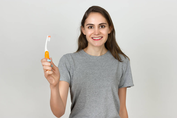 Bella giovane donna dà uno spazzolino da denti
 - Foto, immagini